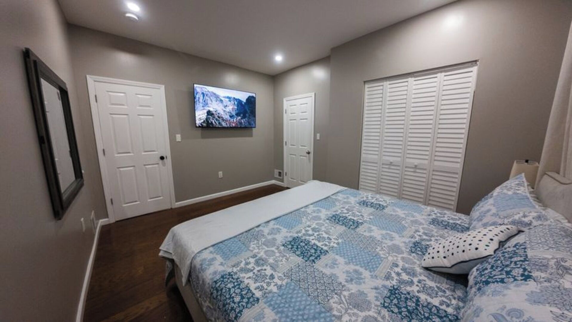 Ein Schlafzimmer mit einem Bett, einem Fernseher und einem Kleiderschrank.