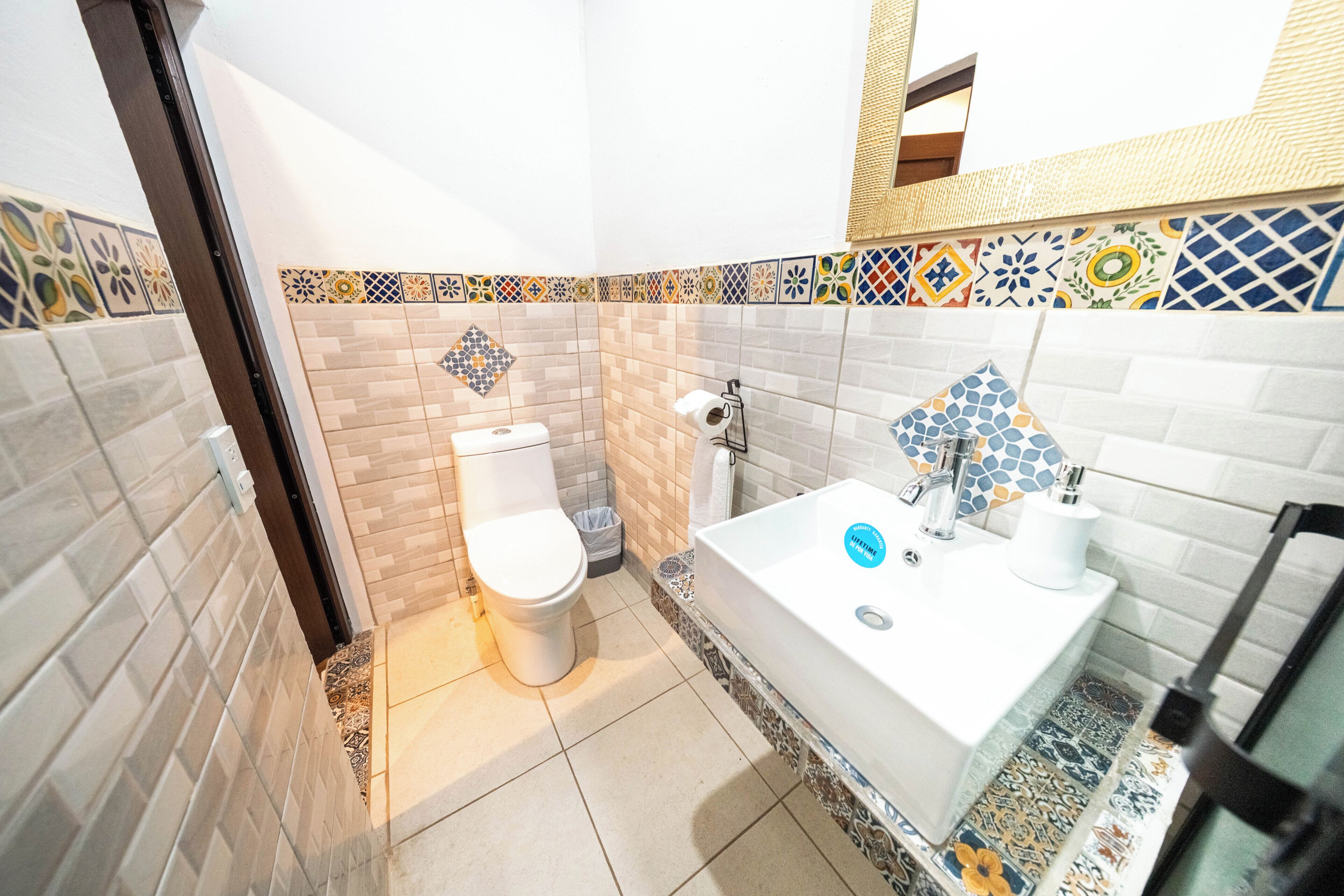 A bathroom with a toilet, sink, and shower area.