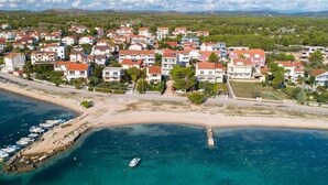 An aerial view of a coastal residential area with houses, a beach, and boats. - Apartments Ana - Studio apartment (Srima)