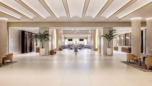 A spacious lobby with a central reception desk, large potted plants, and modern lighting fixtures. - Caesars New Orleans Hotel & Casino - A Caesars Rewards Destination (New Orleans)