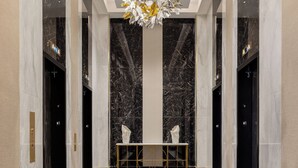 A modern lobby with marble floors, a central table, and a decorative hanging element. - Caesars New Orleans Hotel & Casino - A Caesars Rewards Destination (New Orleans)
