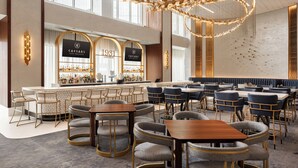 A spacious lounge with multiple seating areas, a bar, and a large decorative light fixture. - Caesars New Orleans Hotel & Casino - A Caesars Rewards Destination (New Orleans)