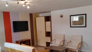 A living room with a sofa, two armchairs, a coffee table, a TV, a wardrobe, and a framed picture on the wall. - Villa Horizont - Four Bedroom Villa with Sea View (Fazana)