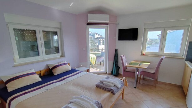 A bedroom with a bed, a desk, and a chair. There is a window with blinds and an air conditioning unit on the wall. - Villa Horizont - Four Bedroom Villa with Sea View (Fazana)