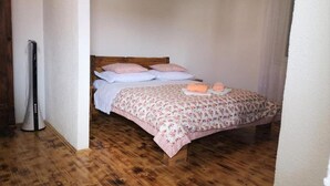 A bedroom with a wooden bed, a bedside table, and a wall-mounted heater. - Apartments Kao Nekad - Two bedrom apartment (Primosten)