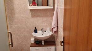 A bathroom with a sink, mirror, and a towel hanging on the wall. - Apartments Kao Nekad - Two bedrom apartment (Primosten)