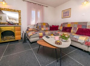 A cozy living room with a sofa, a coffee table, and a fireplace. - Holiday home Kuzmino - Holiday Home (Primosten)