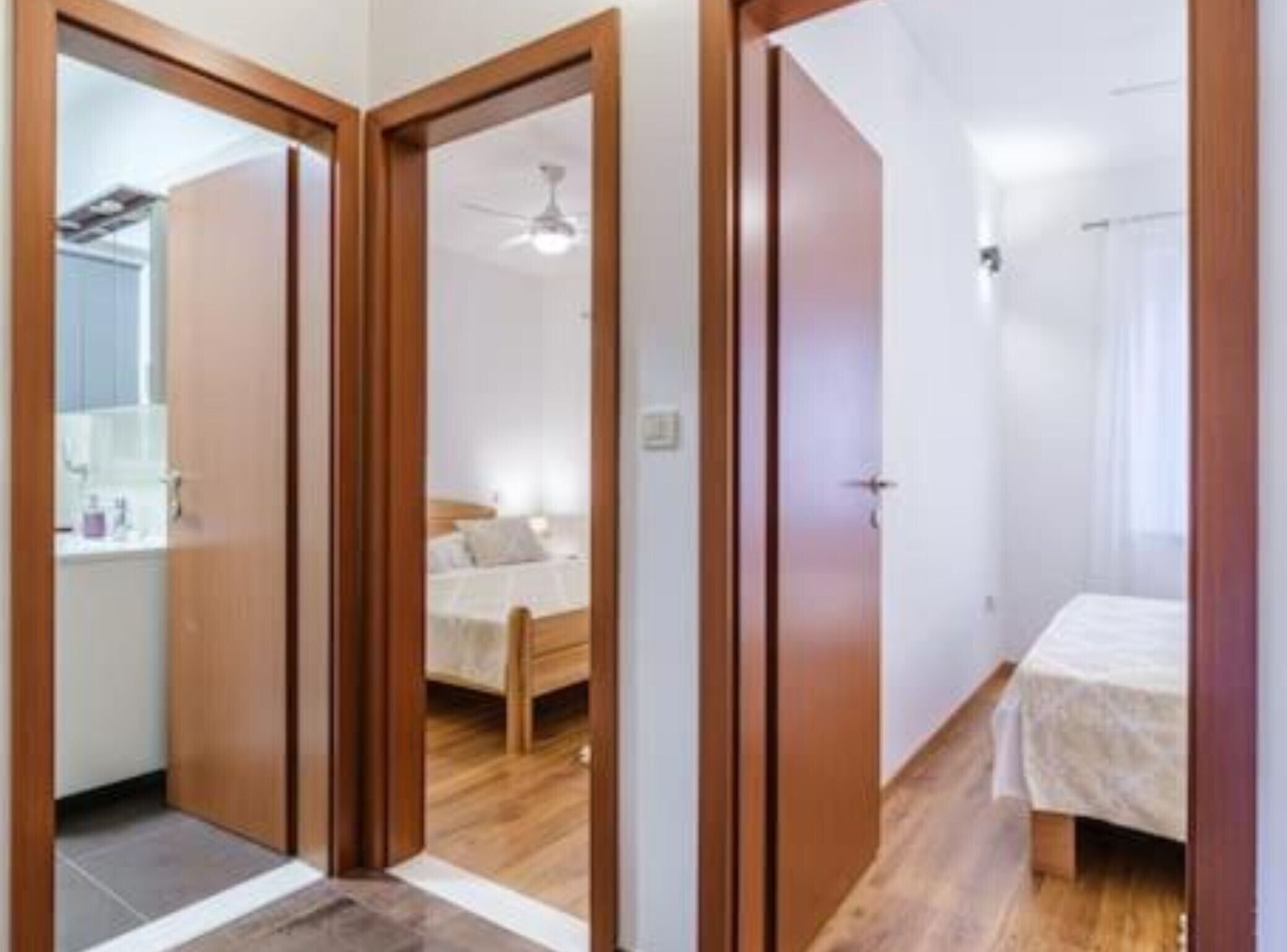 A bedroom with a wooden bed, a bedside table, and a window with curtains.