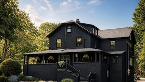 A two-story black house with a porch, a staircase, and a stone border. - Stay at Good Harbor Beach (Gloucester)