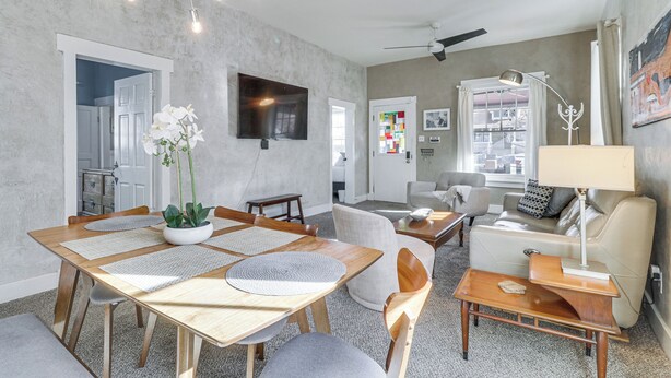 A modern living room with a dining area, a sofa, a TV, and a ceiling fan. - Deck & Home Office: Walkable Albuquerque Home (Albuquerque)