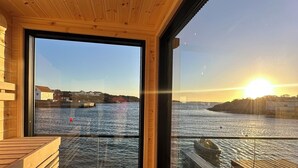Una cabaña de madera con un ventanal grande que da a un cuerpo de agua.