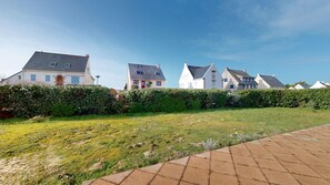 A row of houses with a grassy lawn and a paved walkway. - Villa Houat - Beach less than 100 meters away, sleeps 10 (La Turballe)