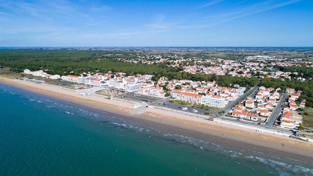 An aerial view of a coastal town with a beach, residential buildings, and a bridge connecting the areas. - Escale Bleu - House with Heated Pool (Notre-Dame-de-Monts)
