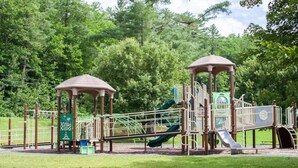 A playground with two gazebos, a slide, and climbing structures. - Littleton: Walk to Downtown, Adventure All Year (Littleton)
