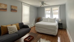 A bedroom with a bed, a sofa, a coffee table, and a ceiling fan. - Littleton: Walk to Downtown, Adventure All Year (Littleton)