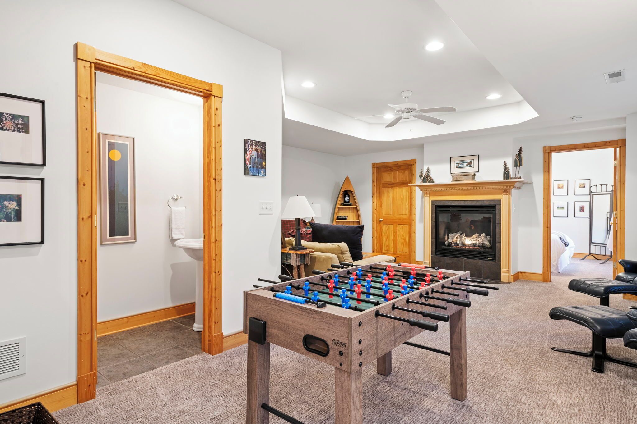 Une pièce avec une table de baby-foot, une cheminée et un canapé.