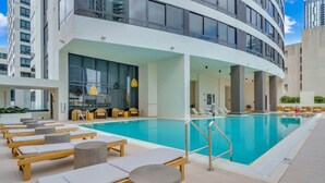 A modern indoor pool area with lounge chairs and a bar area. - Downtown Miami Studio – Pool, Sauna & Free Parking (Miami)
