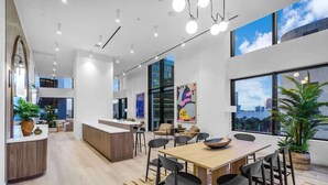 A modern interior with a central dining area, a kitchen, and a reception desk. - Downtown Miami Studio – Pool, Sauna & Free Parking (Miami)