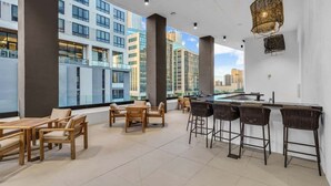 A modern rooftop bar with wooden furniture and a bar counter. - Downtown Miami Studio – Pool, Sauna & Free Parking (Miami)