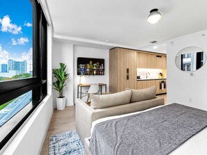 A modern apartment with a bed, a sofa, a dining area, and a kitchen. - Downtown Miami Studio: Pool, Spa & Parking (Miami)