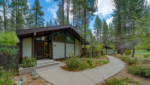 A modern house with a concrete driveway, surrounded by trees and a small garden. - Pet friendly, fully fenced, A/C (Graeagle)