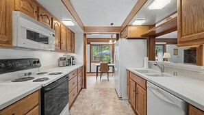 A modern kitchen with wooden cabinets, a built-in microwave, a stove, and a dishwasher. - Pet friendly, fully fenced, A/C (Graeagle)