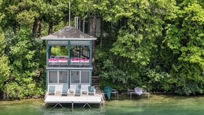 A floating structure with a balcony, seating, and a covered area. - Villa von Baumbach - Trade Screens for Stories (Elkhart Lake)