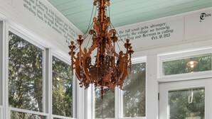 A dining room with a wooden table set for four, surrounded by large windows with a view of trees. - Villa von Baumbach - Trade Screens for Stories (Elkhart Lake)