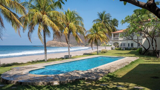 Piscina com vista para a praia e oceano.