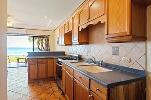 Une cuisine avec des meubles de rangement en bois, un évier et une cuisinière.