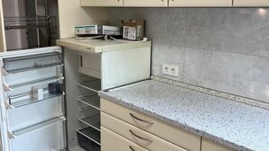 A kitchen with beige cabinets, a granite countertop, and a built-in oven. - Sindel Living Apartment-Freshly renovated 2-bedroom apartment with floor heating (Sindelfingen)