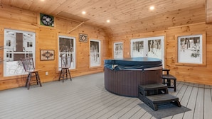 A wooden cabin interior with a hot tub, wooden floors, and large windows. - Wild, Wild West Side! Hot tub, Games, Dog Friendly (Conway)