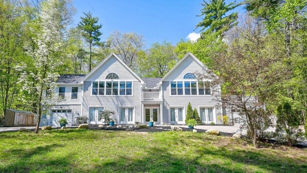 A two-story house with a symmetrical facade, large windows, and a front porch.