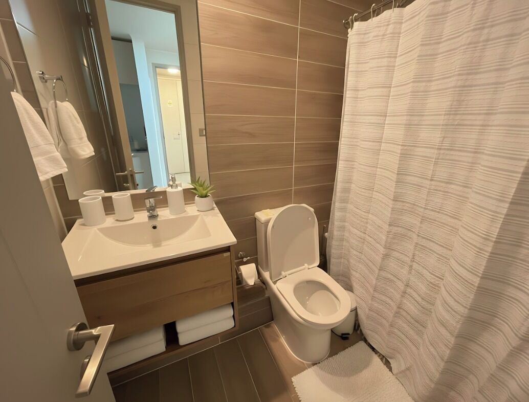 Ein modernes Badezimmer mit Waschbecken, Toilette und Duschvorhang.