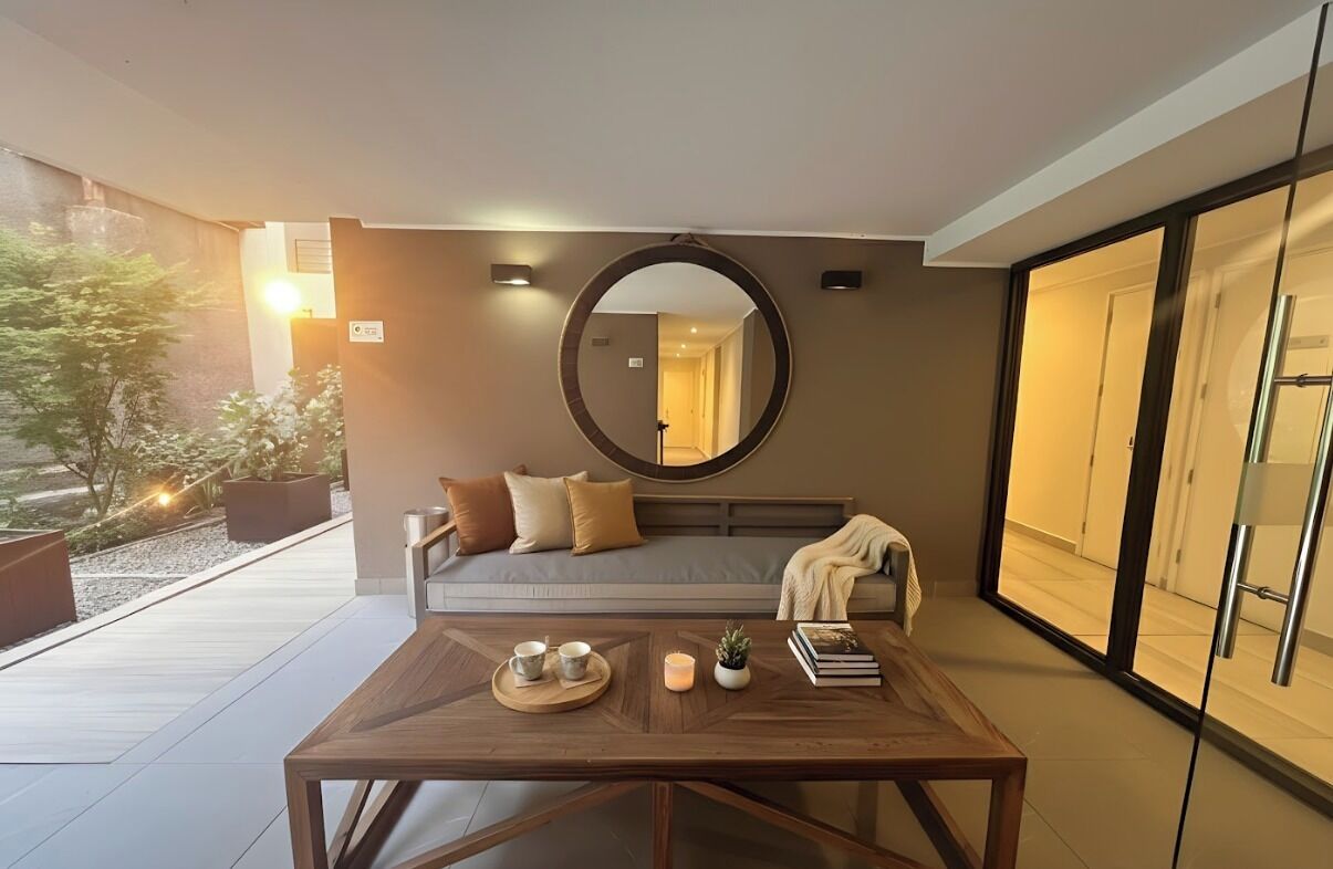 A modern living room with a sofa, a coffee table, and a large mirror.