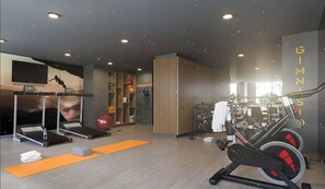 A gym with treadmills, a stationary bike, and a punching bag. - Movistar Arena Santiago - Domus Travels (Santiago)