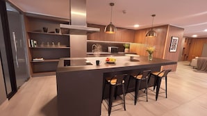 A modern kitchen with a central island, bar stools, a microwave, and a built-in oven. - Movistar Arena Santiago - Domus Travels (Santiago)