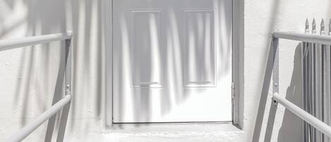 A white door with a window above it and a number '608' on the wall to the right.