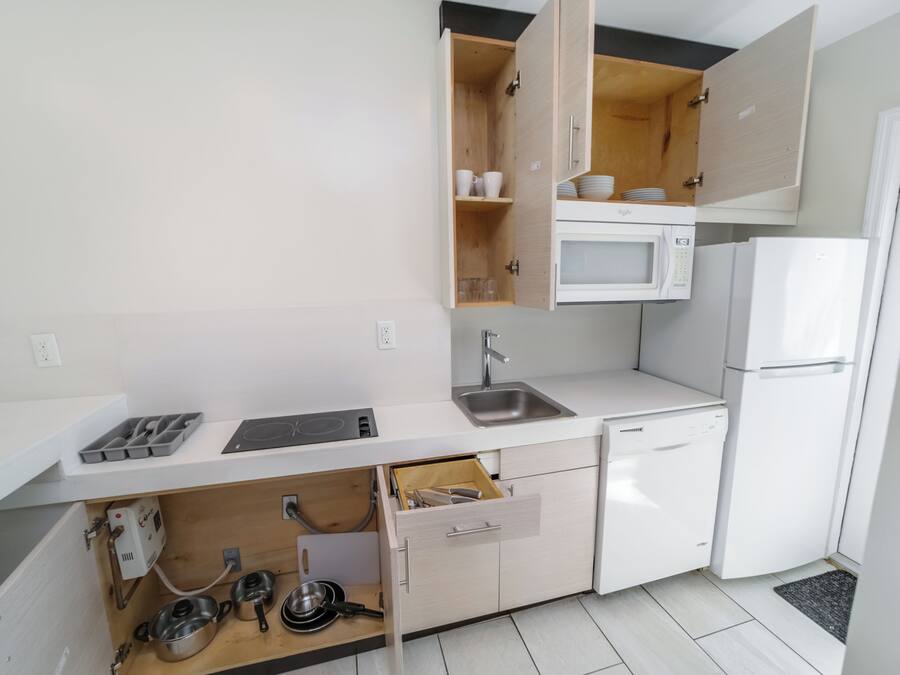 A compact kitchen with a microwave, sink, and built-in oven.