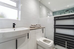 A modern bathroom with a white sink, a toilet, and a towel rack. - Ideal for contractors & long term stays - Sleeps 5 (Halifax)