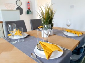 A dining table set with plates, glasses, and a yellow napkin. - Spacious 3BR - Nr Clifton Train Station 510min Walk - Garden & Free Parking (Manchester)