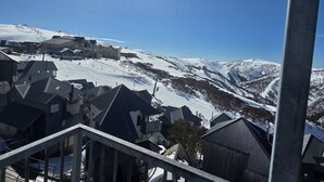 Une montagne enneigée abritant une station de ski, avec des bâtiments et des remontées mécaniques.