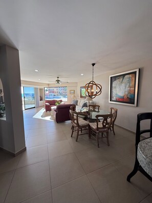 A spacious living area with a dining table, chairs, and a ceiling fan. - Spacious 2BR 2BA Beachfront Walk-Out Condo in Terrasol Resort, Cabo San Lucas (Cabo San Lucas)