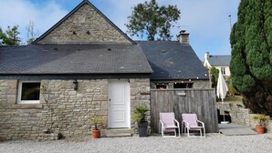 A stone building with a sloped roof, a white door, and two lounge chairs outside. - Comfortable gîte in the heart of the Cotentin region, ideal for families (La Hague)