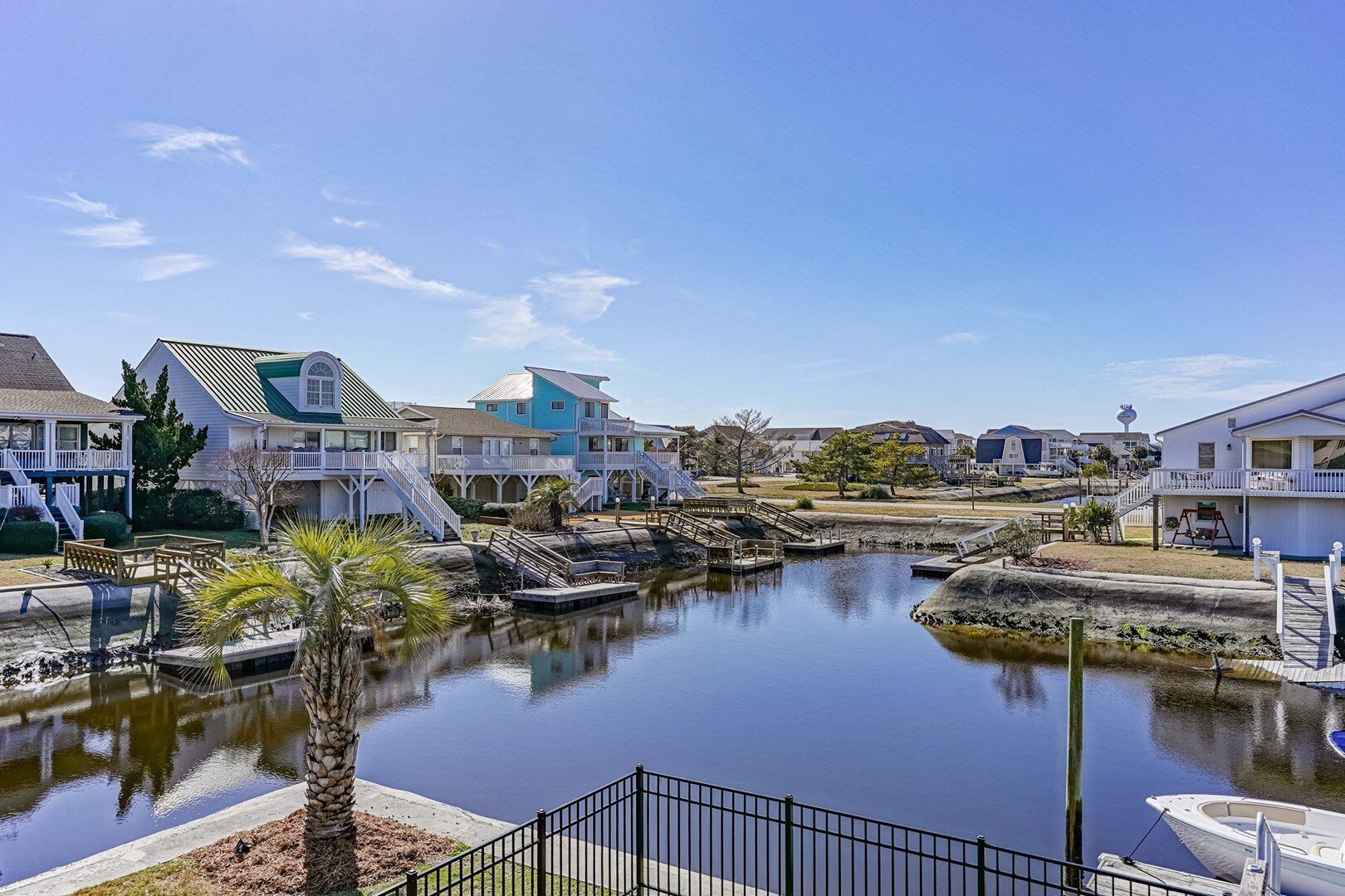 A waterfront property with multiple houses, a dock, and a small waterway.