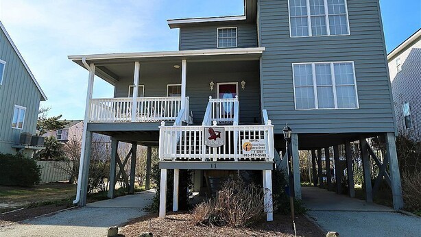 A two-story house with a balcony on the ground floor. - 5 Bedroom Quiet Neighborhood Short Walk to Beach (Ocean Isle Beach)