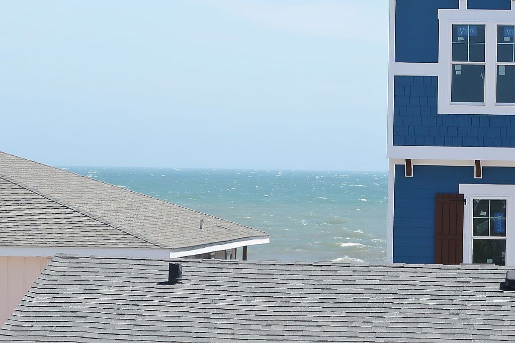 Un edificio con fachada azul y vista al océano.