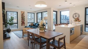 A modern kitchen with a central island, large windows, and a view of the city. - The Big Lohbow-Ski Haus (Revelstoke)