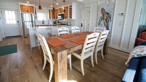 Un'ampia cucina con mobili in legno, un'isola centrale e luci a sospensione.