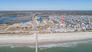 An aerial view of a coastal area with a beach, a marina, and a residential area with houses and buildings. - 5 bedroom house with pool, close to center of town (Ocean Isle Beach)
